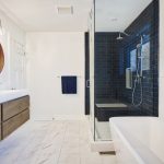 Ensuite bathroom; bathroom renovation; mississauga; dark blue wall tile; white floor and walls; wood floating vanity cabinet